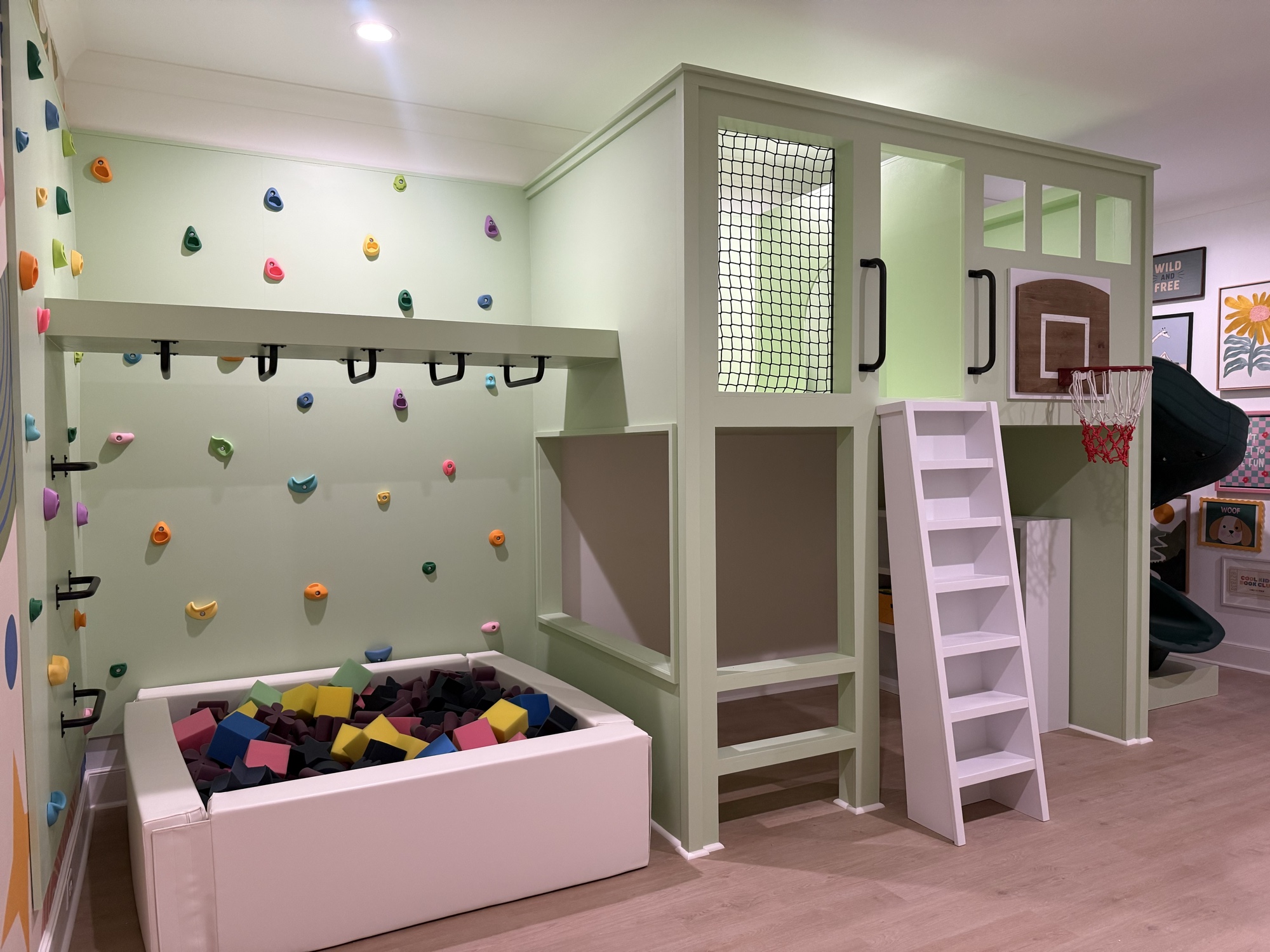 Children's playroom with climbing wall, ball pit, and basketball hoop