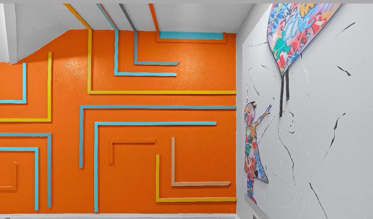 Bold orange playroom with geometric wall art and mural