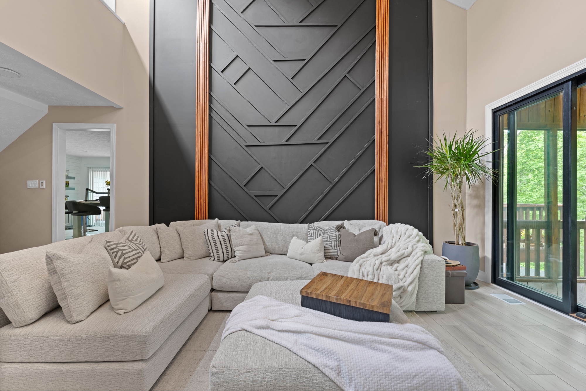 Living room with dramatic geometric black accent wall and sectional