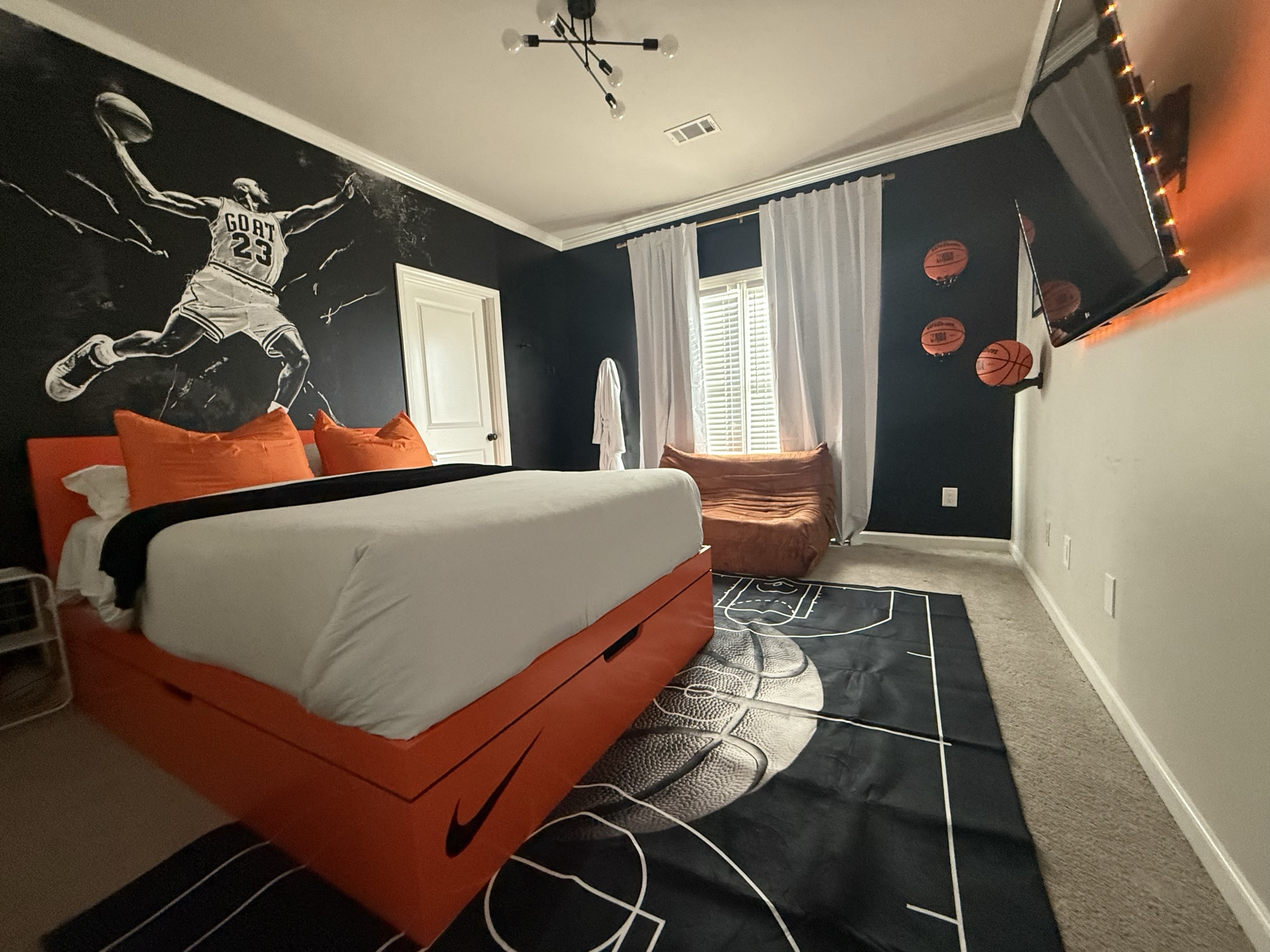 Basketball-themed kids bedroom with Michael Jordan mural and court rug
